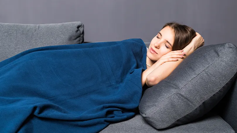 Image d'une femme dormant sous une couverture lestée