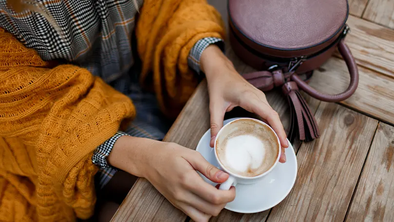 Image d'une personne buvant un café à l'extérieur.