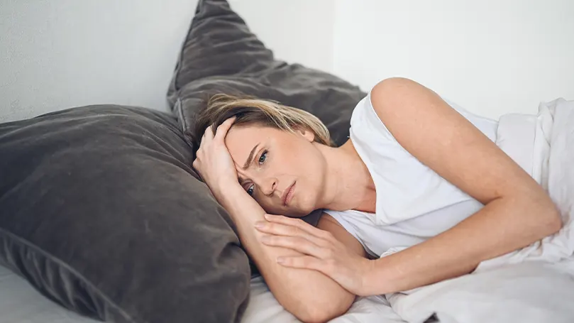 Image d'une femme stressée dans son lit