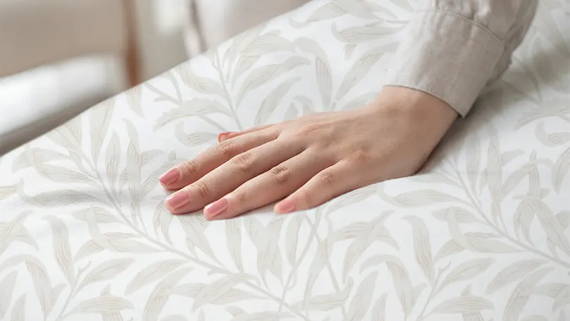 Image d'une main de femme sur un drap.