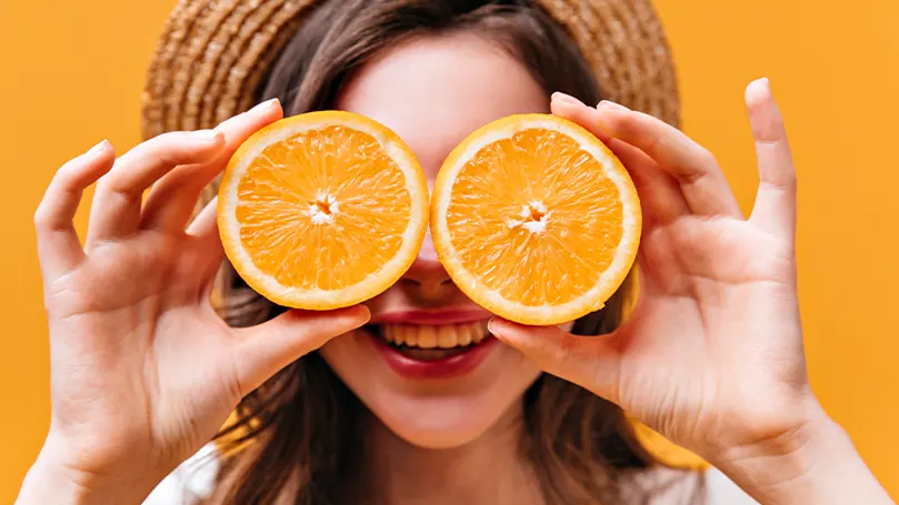 Image d'une femme tenant des oranges.