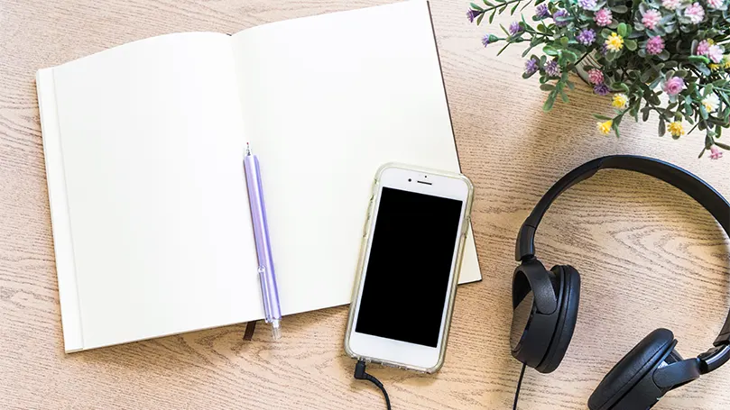 Image d'un cahier et d'un téléphone sur un bureau.