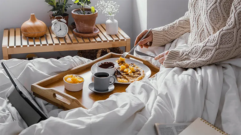 Image d'une personne mangeant dans son lit.
