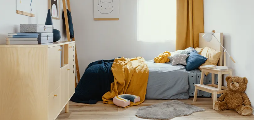 Chambre à coucher avec lit en bois et mobilier bleu marine et jaune.