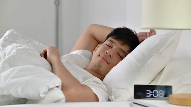 Un jeune homme asiatique dormant dans son lit
