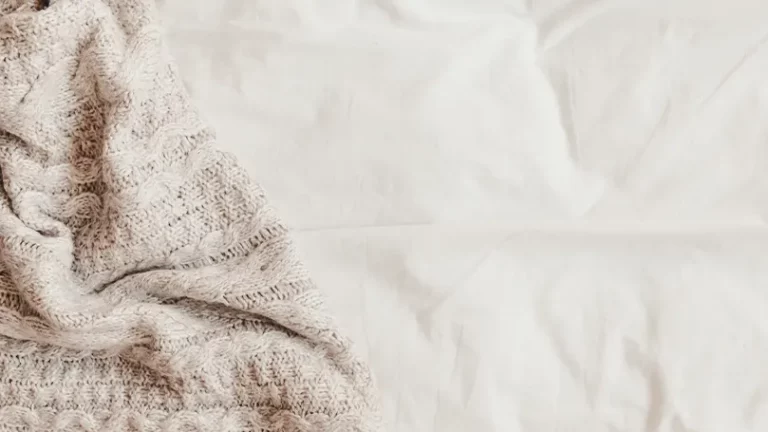 Image d'une couverture placée sur des draps de lit