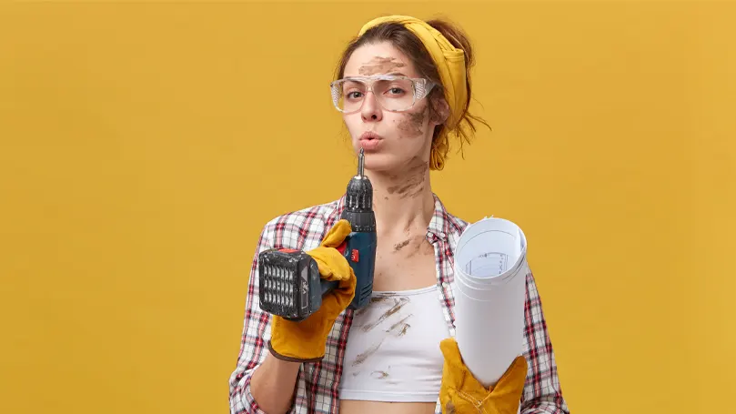 Image d'une femme avec des outils reprenant son souffle après un projet de bricolage.