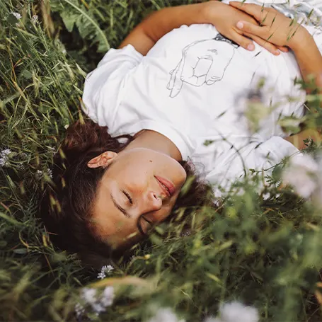 Image d'une femme dormant à l'extérieur dans l'herbe