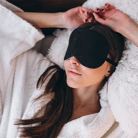 Image d'une femme avec un masque de sommeil dormant sur le dos