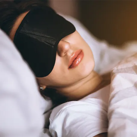 Image d'une femme dormant avec un masque de sommeil