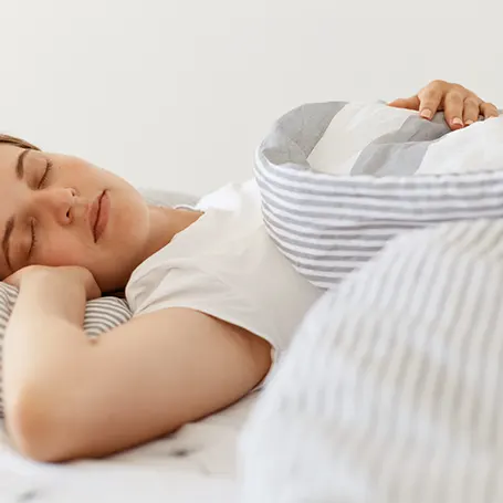 Image d'une femme dormant sur un matelas avec un bon soutien dorsal