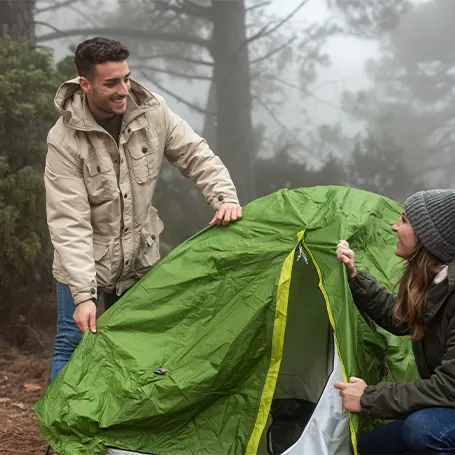 Image de deux personnes en train de monter leur tente