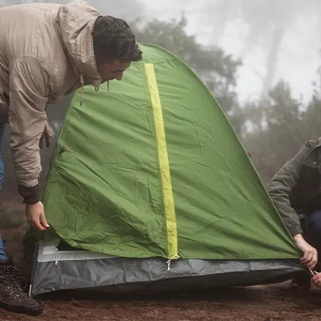Image d'un couple en train de monter une tente étanche