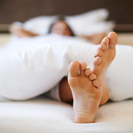 Image d'une femme dormant dans son lit avec sa literie antiallergique.